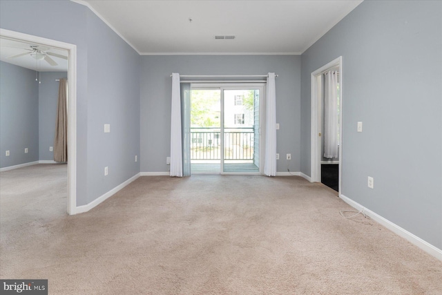 carpeted spare room featuring ceiling fan, visible vents, ornamental molding, and baseboards