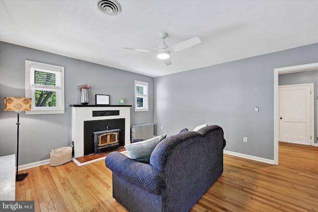 living area featuring a ceiling fan, wood finished floors, and a wealth of natural light