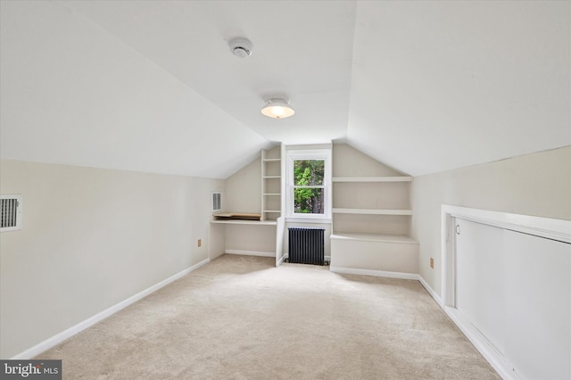 bonus room featuring built in features, carpet, radiator, baseboards, and vaulted ceiling
