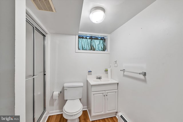 bathroom with toilet, visible vents, wood finished floors, and a stall shower
