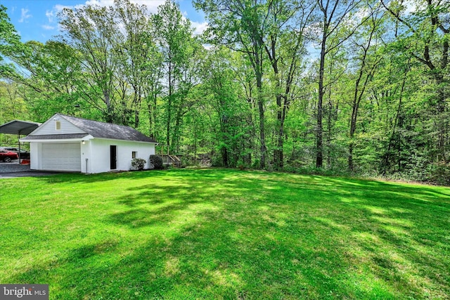 view of yard with a garage, a carport, and driveway