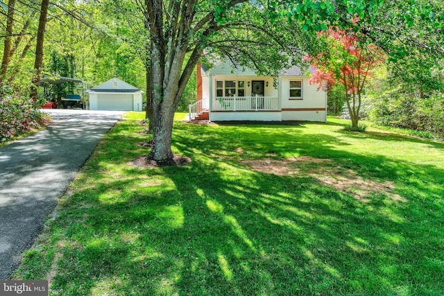 view of yard with a porch, an outdoor structure, and a detached garage