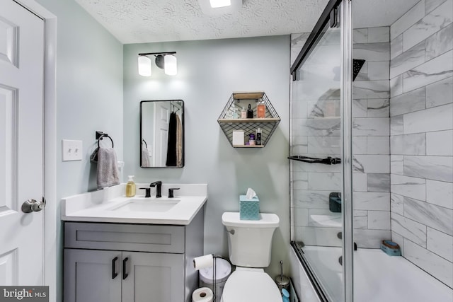 bathroom with toilet, a textured ceiling, bath / shower combo with glass door, and vanity