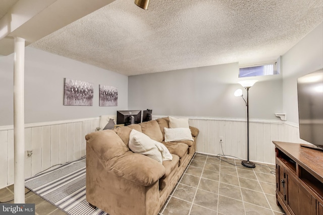 living area featuring wainscoting and a textured ceiling