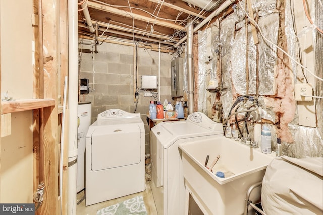 laundry room featuring laundry area, electric panel, a sink, water heater, and washer and dryer