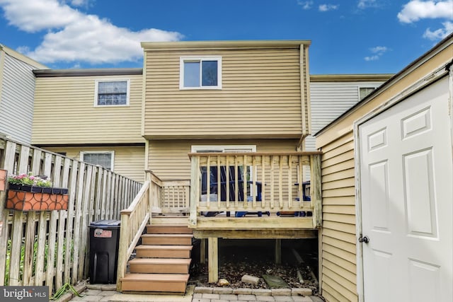 rear view of property with stairs, fence, and a deck