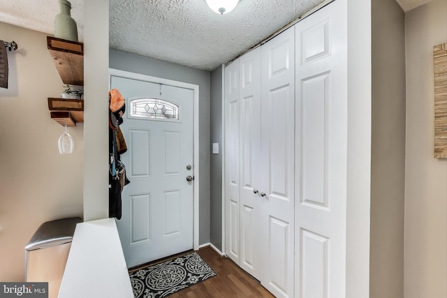 entryway featuring a textured ceiling and dark wood finished floors
