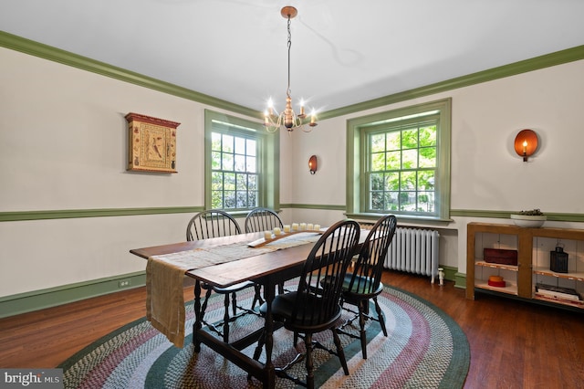 dining space featuring ornamental molding, radiator, wood finished floors, and a chandelier