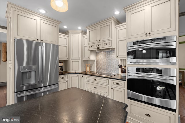 kitchen featuring recessed lighting, appliances with stainless steel finishes, decorative backsplash, and cream cabinetry