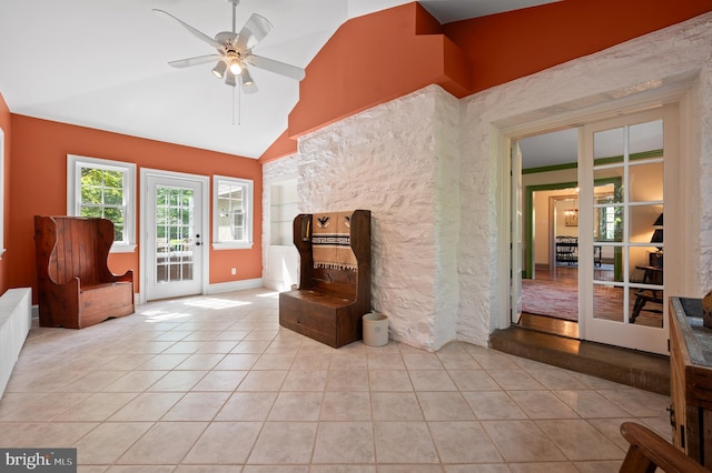 unfurnished room featuring a ceiling fan, lofted ceiling, and light tile patterned floors