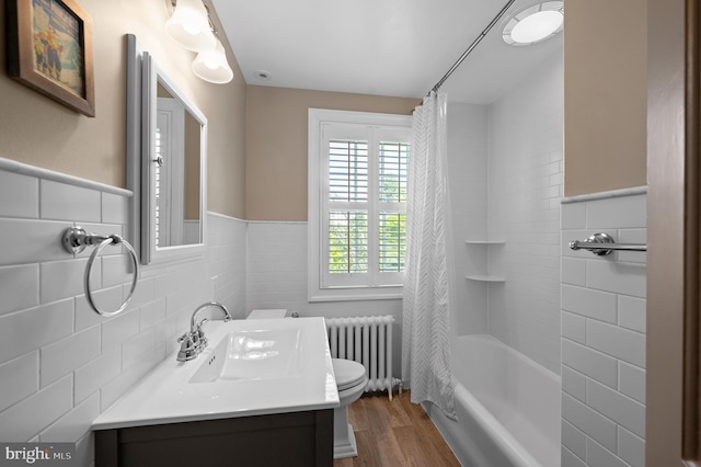 full bathroom with wood finished floors, a wainscoted wall, vanity, toilet, and radiator