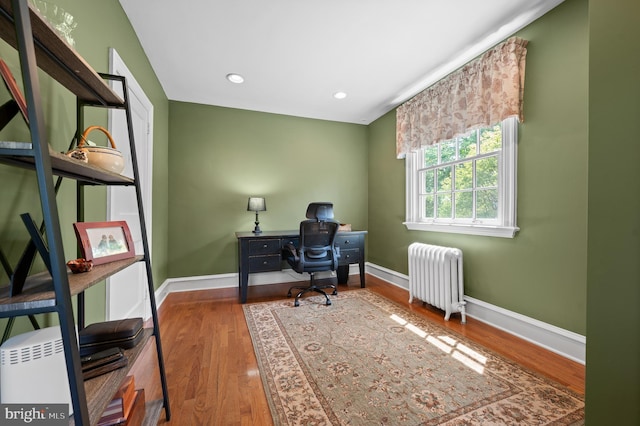 home office featuring recessed lighting, baseboards, radiator heating unit, and wood finished floors