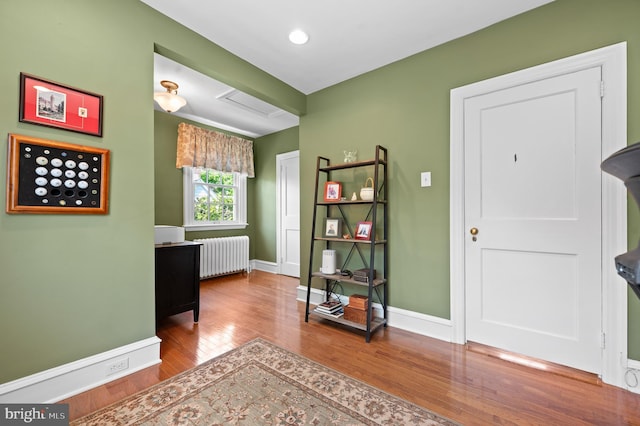interior space featuring radiator, baseboards, recessed lighting, and wood finished floors