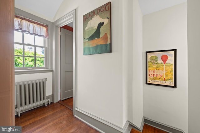 corridor featuring radiator heating unit, vaulted ceiling, and dark wood-style floors