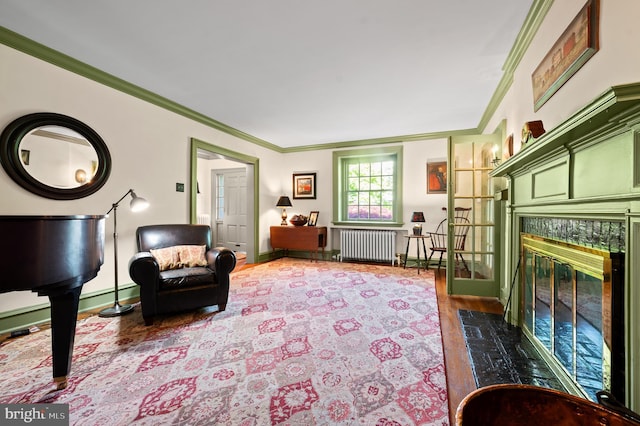 interior space featuring crown molding, radiator heating unit, a fireplace, and wood finished floors