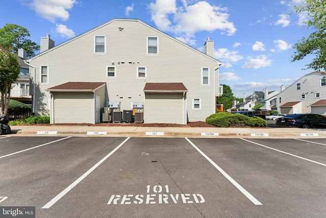 4411 Pembrook Village Dr Unit 101, Alexandria, VA 22309 - back of house featuring a residential view, a chimney, and uncovered parking