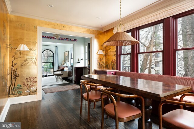 dining room featuring baseboards, ornamental molding, and dark wood finished floors
