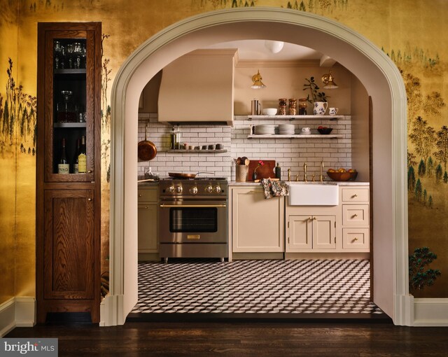 bar featuring dark wood-style flooring, a sink, high end stove, tasteful backsplash, and ornamental molding