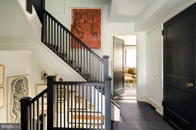 stairs featuring baseboards and carpet