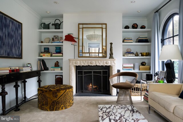 carpeted living area featuring crown molding, a lit fireplace, and built in features