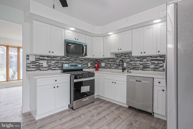 505 University Blvd, Wenonah, NJ 08090 - kitchen featuring stainless steel appliances, a sink, light countertops, white cabinetry, and tasteful backsplash