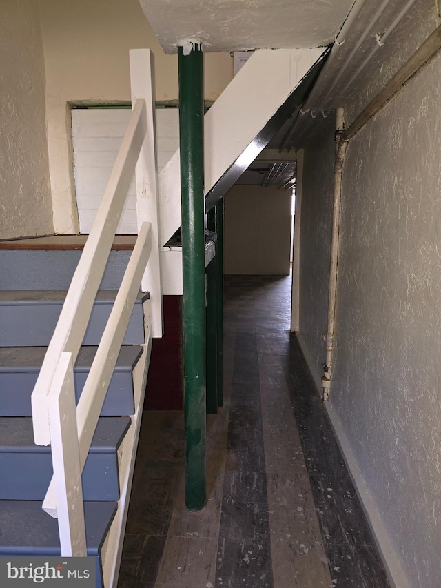 basement with a textured wall and stairway