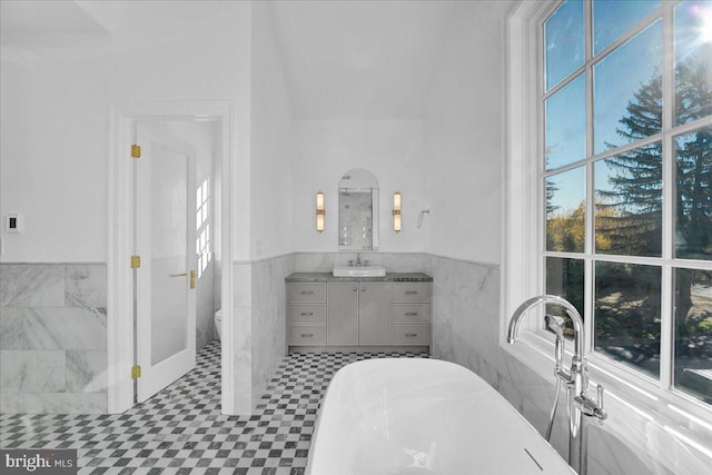 457 Brownsburg Rd W, Unit W, Newtown, PA 18940 - bathroom featuring a freestanding bath, tile walls, a wainscoted wall, vanity, and toilet