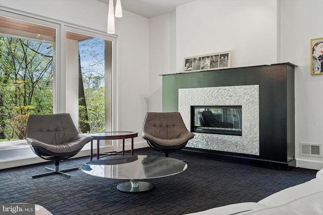 living area featuring a glass covered fireplace and visible vents