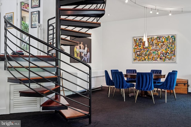 dining space featuring carpet flooring and stairs