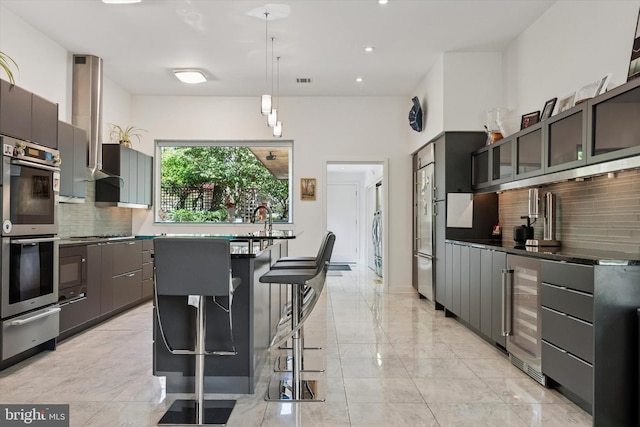 kitchen featuring a warming drawer, appliances with stainless steel finishes, tasteful backsplash, and beverage cooler