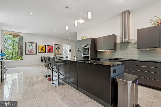 kitchen featuring appliances with stainless steel finishes, modern cabinets, decorative backsplash, and wall chimney exhaust hood