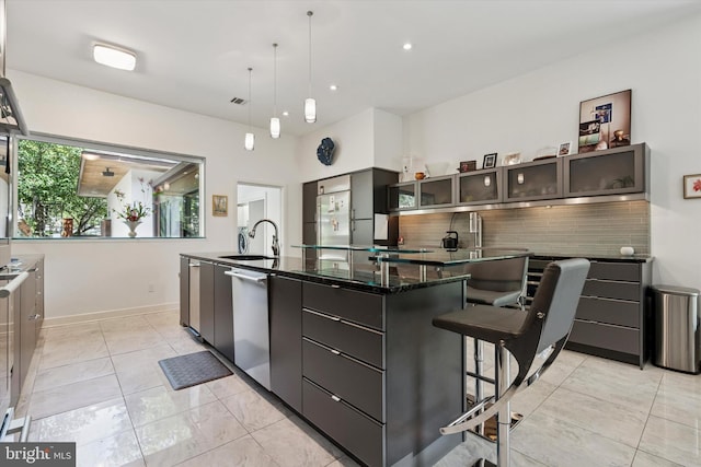 kitchen featuring backsplash, modern cabinets, stainless steel dishwasher, a large island with sink, and a sink