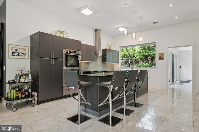 kitchen with visible vents, decorative backsplash, marble finish floor, and stainless steel oven