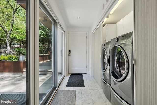 clothes washing area featuring marble finish floor, cabinet space, and washing machine and dryer