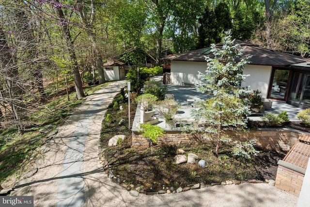 exterior space with an outdoor structure, stucco siding, and a shed