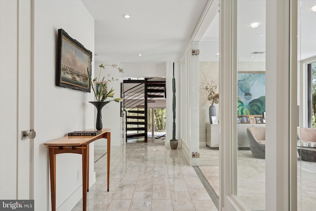 corridor with recessed lighting, marble finish floor, and stairs