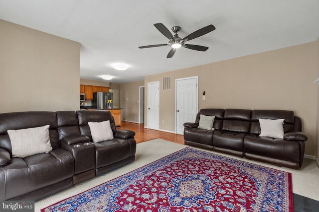 living room with ceiling fan and baseboards