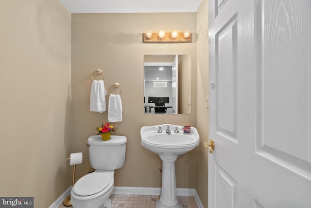 half bath with toilet and baseboards