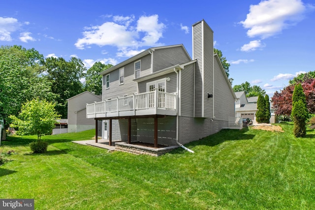 back of house with a deck, a chimney, a lawn, brick siding, and french doors