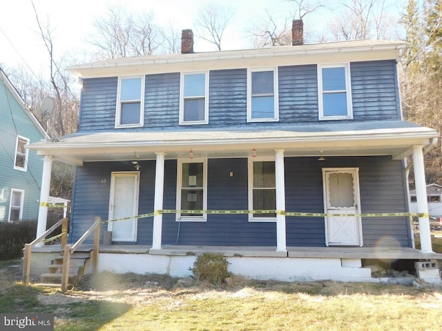 view of front facade featuring a porch and a chimney