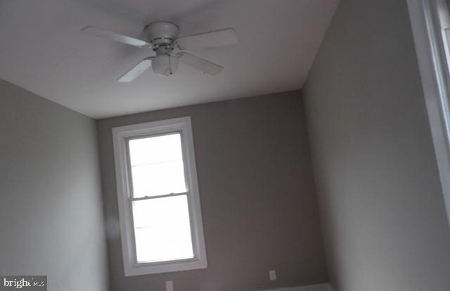 spare room featuring ceiling fan and plenty of natural light
