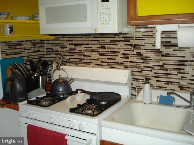 4627 Central Ave NE, Washington, DC 20019 - kitchen with a sink, white appliances, and tasteful backsplash