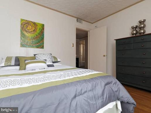 4627 Central Ave NE, Washington, DC 20019 - bedroom with crown molding, a textured ceiling, and wood finished floors