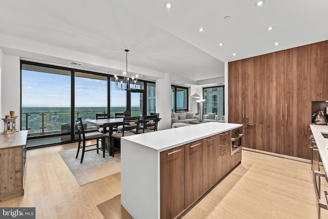 1650 Silver Hill Dr Unit 1706, Mclean, VA 22102 - kitchen with modern cabinets, a center island, light countertops, a chandelier, and light wood-style flooring