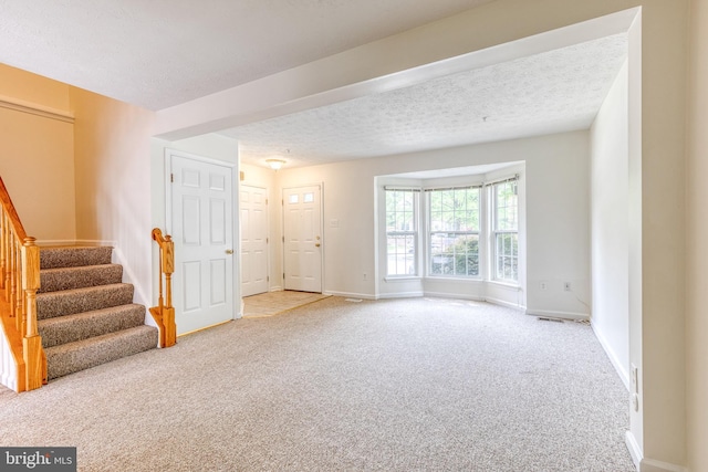 7 Silver Birch Ct, Owings Mills, MD 21117 - unfurnished living room featuring carpet flooring, stairway, and a textured ceiling