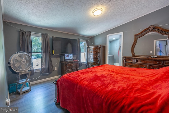 bedroom featuring baseboards, a textured ceiling, vaulted ceiling, and wood finished floors