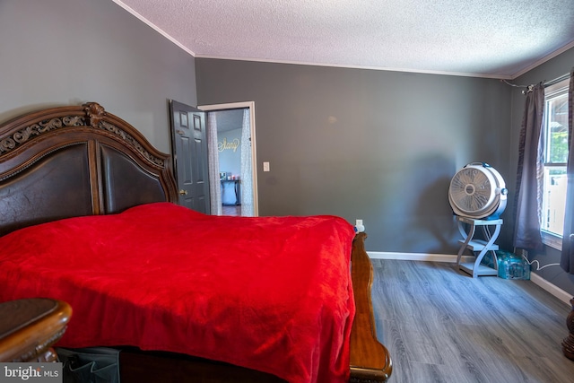bedroom with crown molding, a textured ceiling, baseboards, and wood finished floors