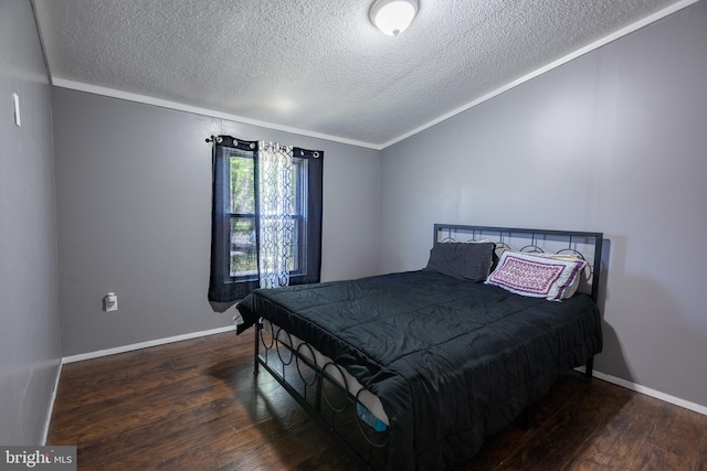 bedroom with wood-type flooring, a textured ceiling, ornamental molding, and baseboards