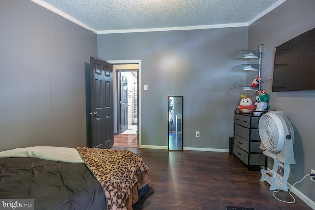 bedroom with baseboards, a textured ceiling, ornamental molding, and wood finished floors