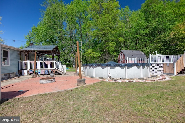 view of yard featuring a patio, a deck, and a covered pool